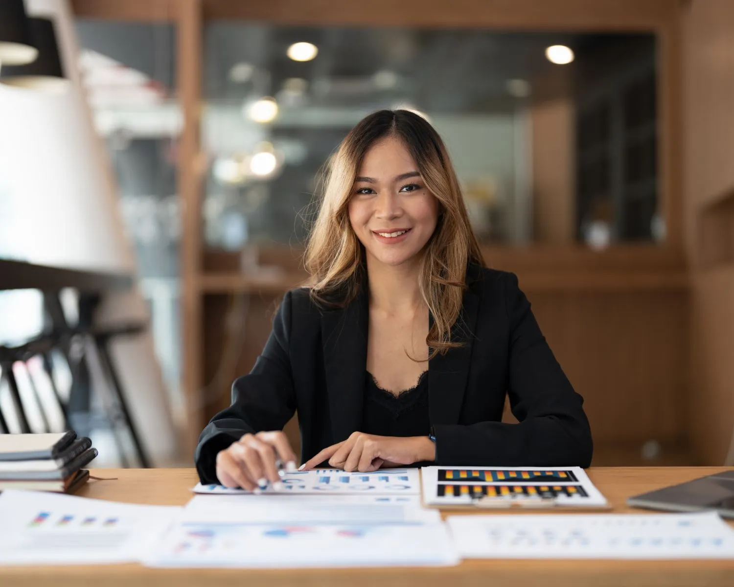 Cute accountant women smiling at her desk working on paperwork.